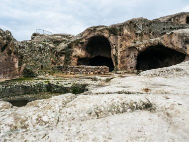 Uplistsikhe (The Lord 's Fortress), inanılmaz UNESCO mağara şehrinin dünya mirası, mavi gökyüzü arka planında doğa taşı manzarası olan antik kaya yontulmuş kasaba, Georgia' da ünlü seyahat cazibesi.