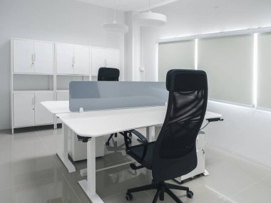 Yeni ofis dekorasyonu, mobilyalarla dekorasyon, siyah ergonomik sandalyeler ve masa bölünmesi, dosya ve ekipman dolabı olan elektrik yüksekliği ayarlanabilir masa..