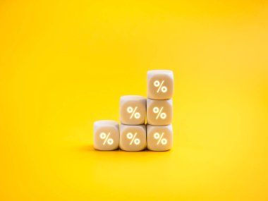 Sarı arka planda üst üste yığılmış yüzdelik işaretli beyaz küpleri. İş büyümesi, artan kar, gelir, satış performansı, yatırım dönüşü ve mali başarı stratejisi kavramı.