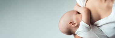 Nötr renk tonuyla emzirilmiş bir bebeğin yakın çekimi. Ebeveynlik ve sağlık teması için ideal, metin için kopyalama alanı var. Geniş pankart kullanımı için uygun.