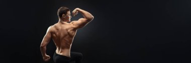 Kaslı bir adam arka planda sırt kaslarını esnetiyor. Bu geniş pankart, fotokopi alanı ile güçlü bir fiziğe sahip, fitness promosyonları için ideal..