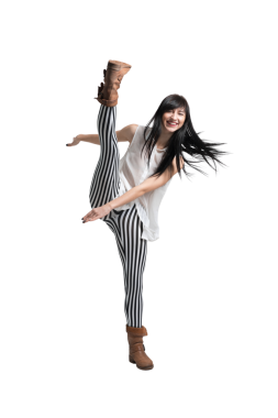 Uzun siyah saçlı, siyah beyaz çizgili ve kahverengi çizmeli yüksek tekme atan mutlu bir kadın. Fitness, dans veya moda kavramları için mükemmel..