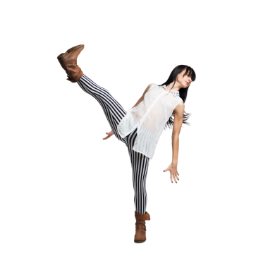 Enerjik dansçı kendine güvenerek yüksek tekme atıyor çizgili tayt ve botlar giyiyor. Dans, moda ya da aktif yaşam tarzı reklamları için mükemmel..