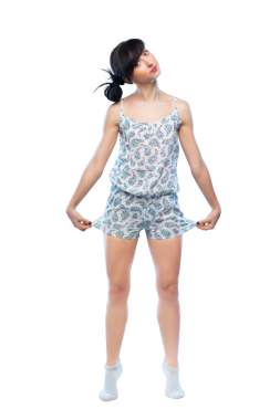 Desenli pijamalı bir kadın, şeffaf bir arkaplanda neşeli duygular gösteren tuhaf bir poz verir. Yaşam tarzı ve ev modası temaları için ideal.