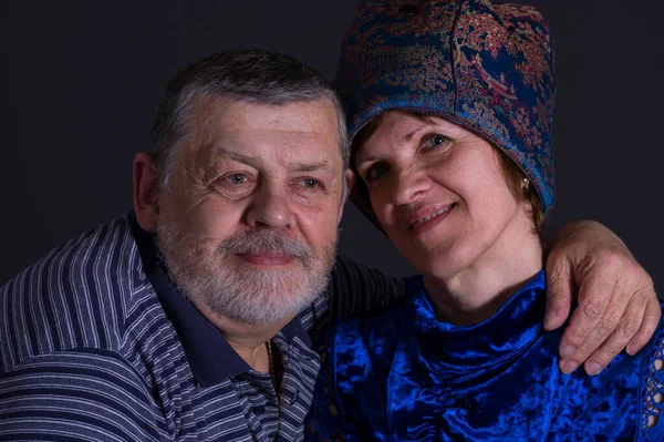 Indoor Positive portrait of senior Caucasian pair - broser and sister in blue oriental clothe