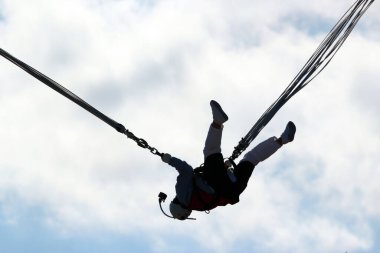 Woman makes selfie in mid-air, hanging on a bungee ropes