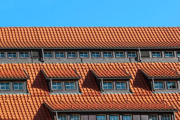 Okna Poddaszu Pomarańczowym Dachu Tle Błękitnego Nieba — Zdjęcie stockowe