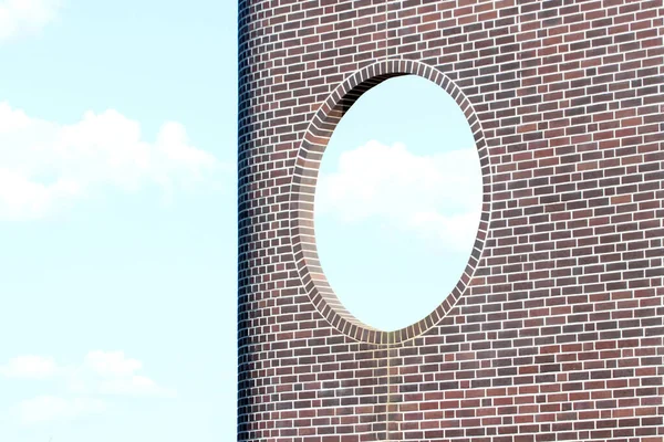 青空を背景に丸い窓のあるレンガの壁 — ストック写真
