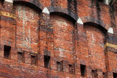 Arka planda çıkıntı blokları olan eski kırmızı tuğla duvar