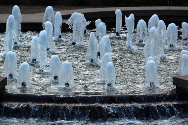 Yazın parkta bir çeşme, havuzda fıskiyeler ve spreyler.