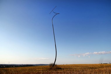 Oelsnitz, Germany - July 30, 2024: Time Vortex sculpture by Paul Fuchs, 17m high steel figure representing a swirling crash, embodying the sudden changes in Earth's history clipart