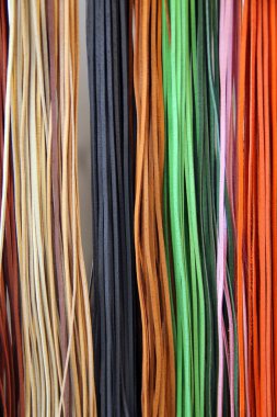 İnce, renkli deri şeritler örgü ve el işi için dekoratif bir arka plan olarak düzenlenmiş.