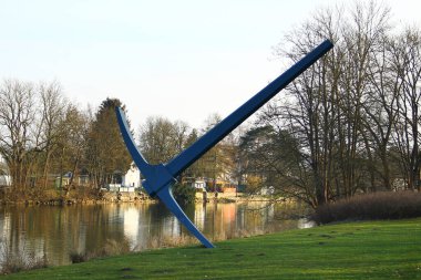Kassel, Almanya - 10 Mart 2025: Kazma, Claes Oldenburg 'un Fulda nehrindeki Hiroşima kıyısındaki çelik heykeli, 1982' de Documenta 7 'ye katkı.