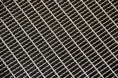 Tekrar eden kare desenli ve endüstriyel desenli köşegen metal bir ızgaranın yakın görüntüsü