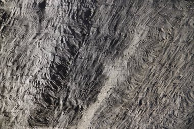 Çapraz mala izleri ve pürüzlü el işi deseni olan desenli beton alçı yüzeyi..