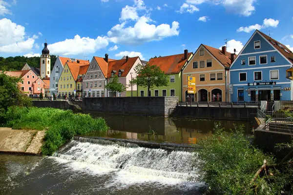 Schwandorf, Almanya - 31 Mayıs 2025: Güneşli bir yaz gününde Schwandorf, Bavyera 'daki tarihi kilise ve nehir kenarındaki renkli evler