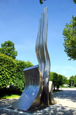 Weiden in der Oberpfalz, Almanya - 31 Mayıs 2025: Weidener Wellen by Otto Wesendonck, 11 metre paslanmaz çelik heykel Weiden, Bavyera 'daki Max-Reger-Halle yakınlarında rüzgarda titreşiyor