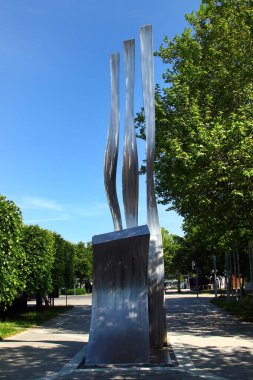 Weiden in der Oberpfalz, Almanya - 31 Mayıs 2025: Weidener Wellen by Otto Wesendonck, 11 metre paslanmaz çelik heykel Weiden, Bavyera 'daki Max-Reger-Halle yakınlarında rüzgarda titreşiyor