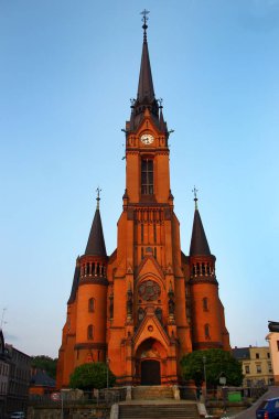 Mylau, Almanya - 9 Haziran 2025: Neo-gotik Evanjelik-Lüteryen Kilisesi günbatımında yüksek kule ve kırmızı tuğla cepheli