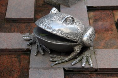 Freiberg, Almanya - 9 Ağustos 2023: Silver City Freiberg 'in simgesi olarak gümüş kurbağa. Şehir yüzyıllardır Ore Dağları 'ndaki madencilik endüstrisinin merkezidir..