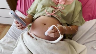 Bebeğin kalp atışlarını hastanede dinlemek için fetal damlalar kullanan hamile kadını kapatın.