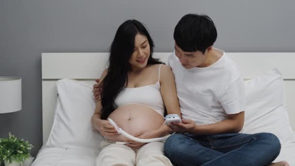 妊娠中の女性とその夫は胎児の心臓の鼓動を聞くために — ストック動画