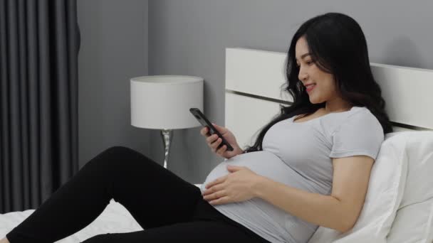 Έγκυος Γυναίκα Που Χρησιμοποιεί Smartphone Κρεβάτι — Αρχείο Βίντεο