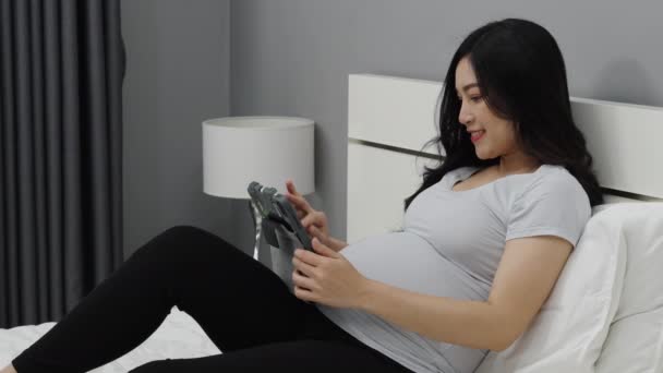 Schwangere Mit Digitalem Tablet Auf Dem Bett — Stockvideo