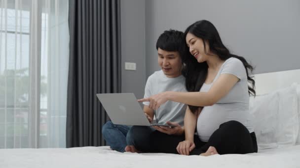 在床上使用笔记本电脑的怀孕夫妇 — 图库视频影像