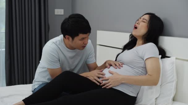 Schwangere Hat Bauchschmerzen Mit Ihrem Mann Auf Dem Bett — Stockvideo