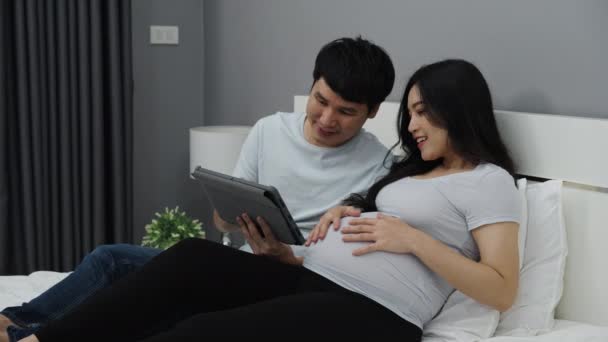 Těhotná Žena Svým Manželem Pomocí Digitálních Tabletu Posteli — Stock video