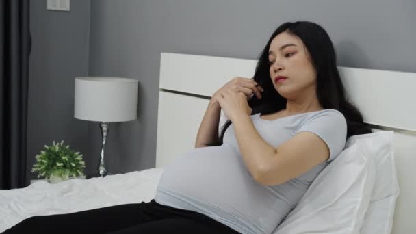 妊娠中の女性はベッドの上で — ストック動画