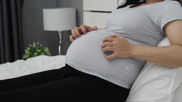 妊娠中の女性のクローズアップは ベッドで腹痛を持っている — ストック動画