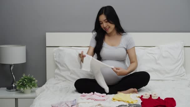 Hamile Kadın Yeni Doğan Için Bebek Kıyafetleri Hazırlıyor — Stok video