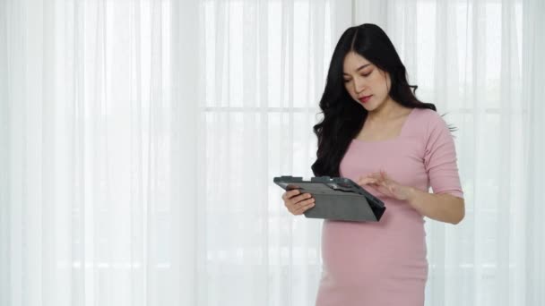 Έγκυος Γυναίκα Που Χρησιμοποιεί Ψηφιακό Δισκίο Φόντο Παραθύρου — Αρχείο Βίντεο
