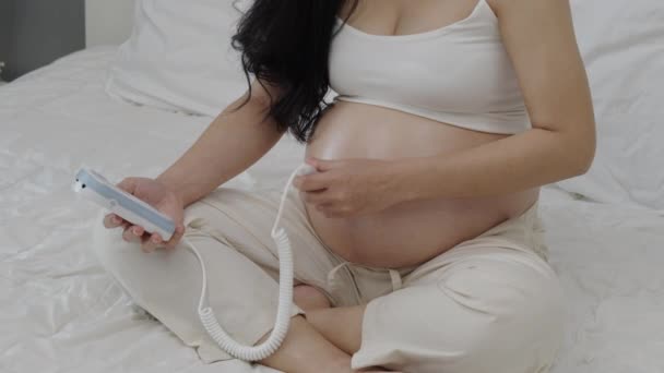 Close Femme Enceinte Utilisant Dispositif Droppler Foetal Pour Écouter Les — Video