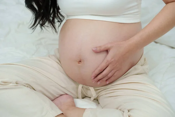 Hamile Bir Kadının Karnını Bir Yatakta Okşaması — Stok fotoğraf