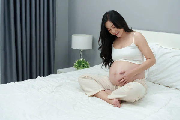 Mutlu Hamile Kadın Yatakta Karnını Okşuyor — Stok fotoğraf