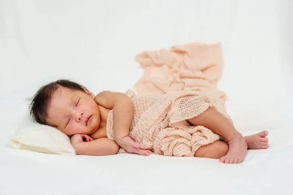 newborn baby sleeping in blanket on a bed