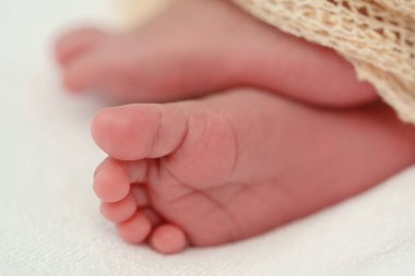 close up feet of newborn baby on a bed