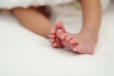 close up feet of newborn baby on a bed
