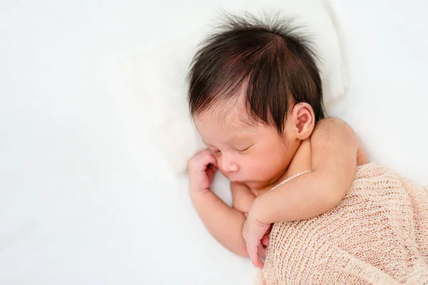 newborn baby sleep in cloth wrap blanket on a bed