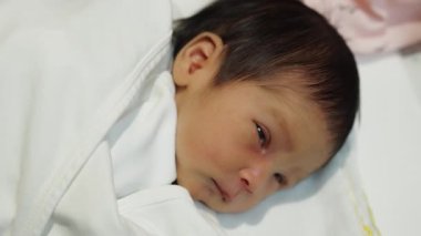 newborn baby laying in the infant bassinet basket at hospital