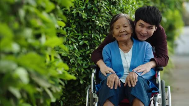 Happy Young Man Grandson Talking Embracing Senior Woman Wheelchair Park — Stock Video