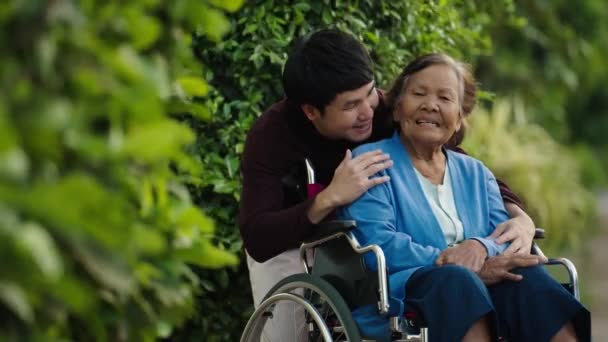 Happy Young Man Grandson Talking Embracing Senior Woman Wheelchair Park — Vídeos de Stock