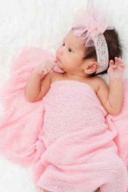 newborn baby girl in blanket on a bed