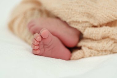 close up feet of newborn baby on a bed