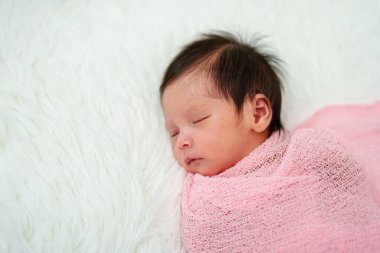 newborn baby sleep in cloth wrap blanket on a bed