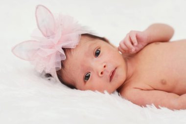happy newborn baby girl on a bed