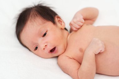 newborn baby yawning on a bed